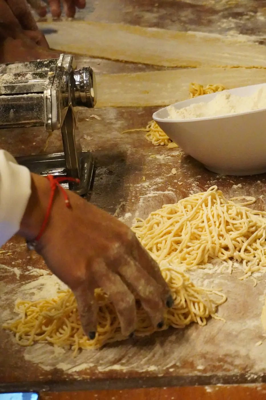 Manos separando spaghetti fresco