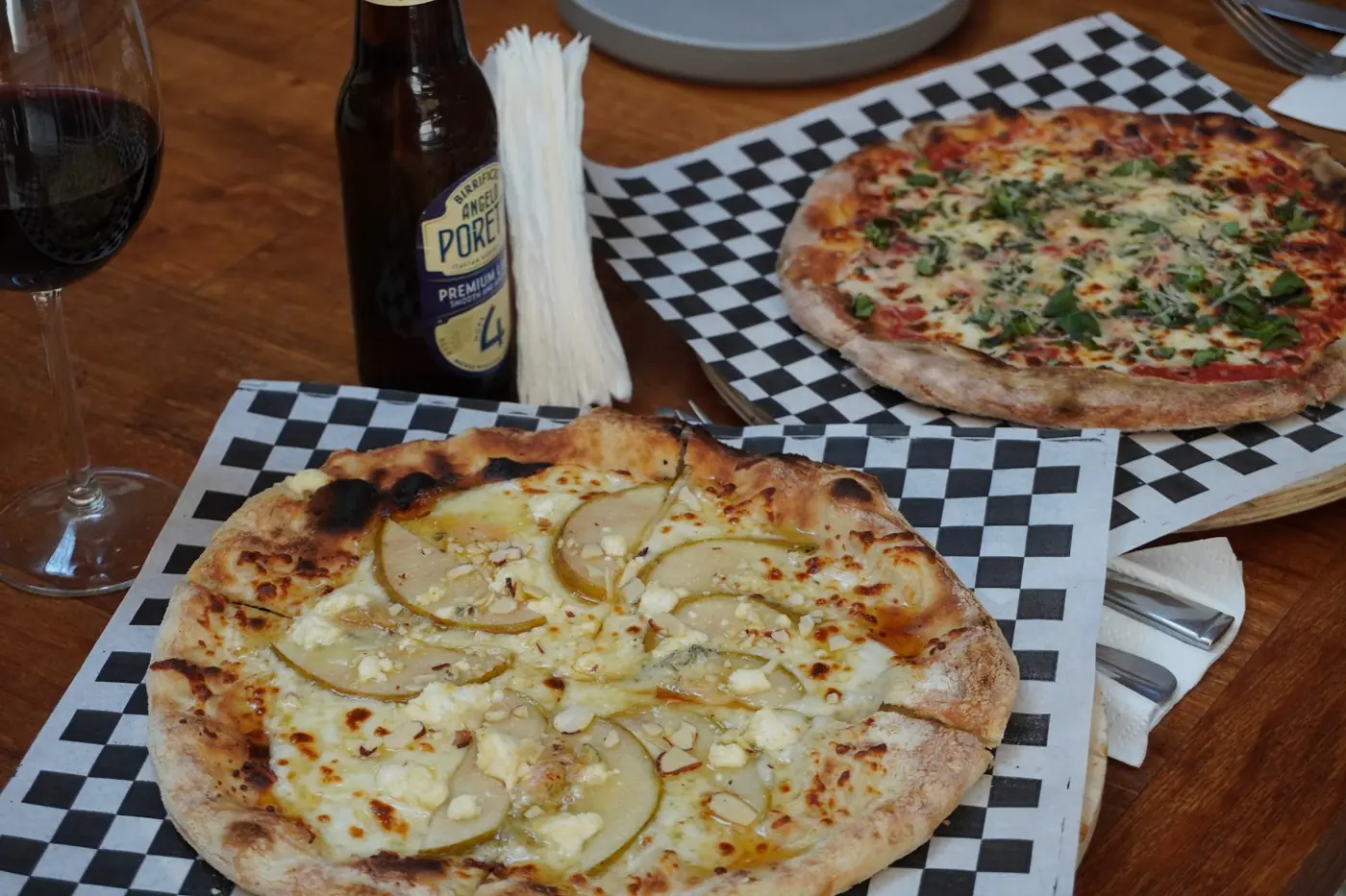 Pizzas recién salidas del horno con vino tinto