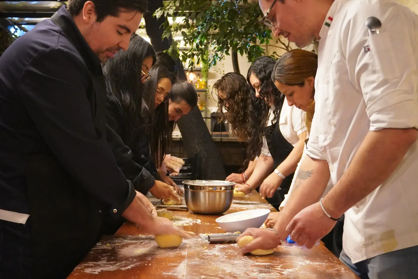Grupo amasando en la mesa larga con el chef